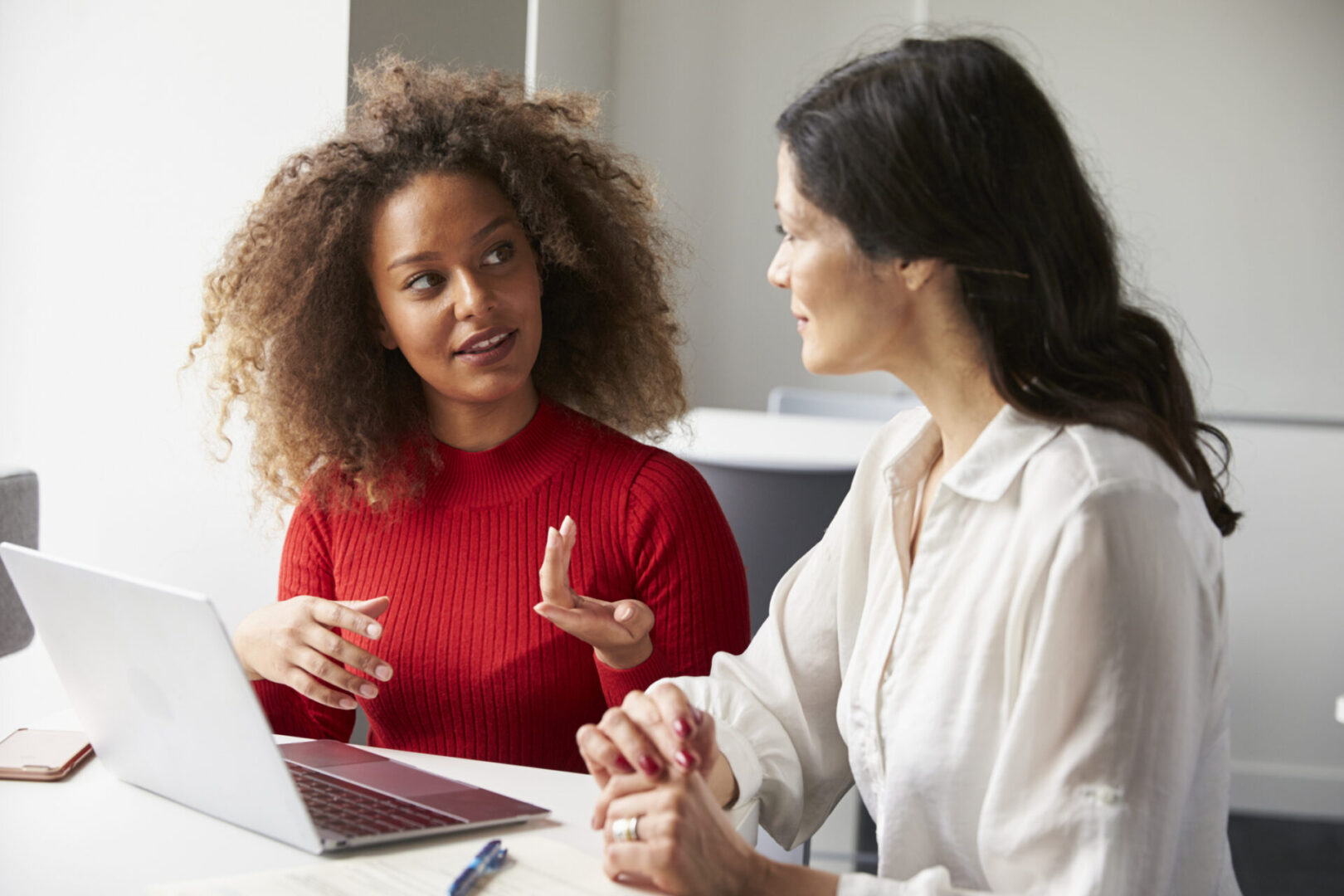 Female University Student Working One To One With Tutor Two women discussing work on laptop.